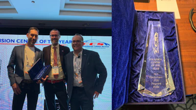 Three professionals receive Collision Centre of the Year award at conference with trophy and event signage