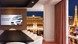 Modern conference room with Plasnomic logo on screen overlooking Las Vegas Strip at night