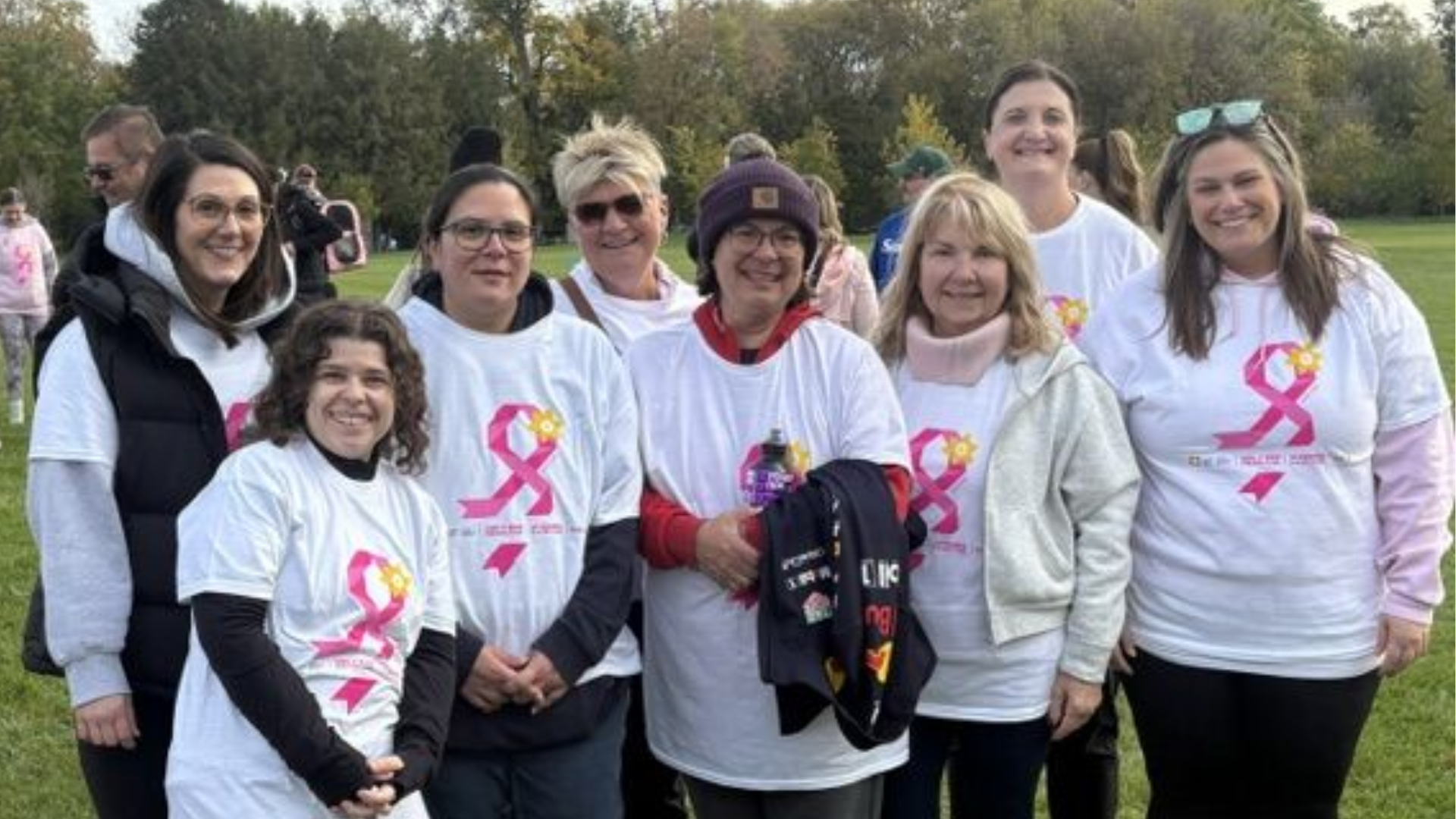 Group of women wearing pink ribbon t-shirts at outdoor breast cancer awareness event
