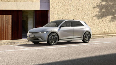 Silver Hyundai Ioniq 5 electric SUV parked in front of modern stone building