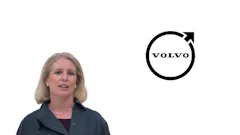 Professional woman in dark blazer with Volvo logo featuring circular design and upward arrow