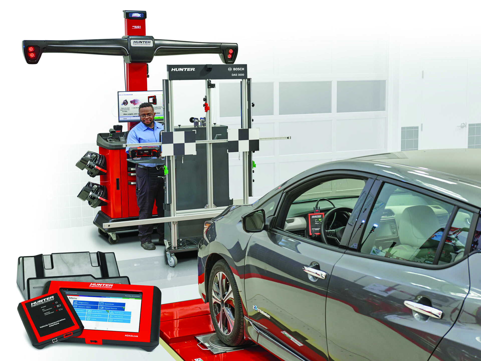 Professional wheel alignment service with Hunter Bosch equipment and technician working on gray vehicle