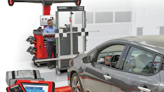 Professional wheel alignment service with Hunter Bosch equipment and technician working on gray vehicle